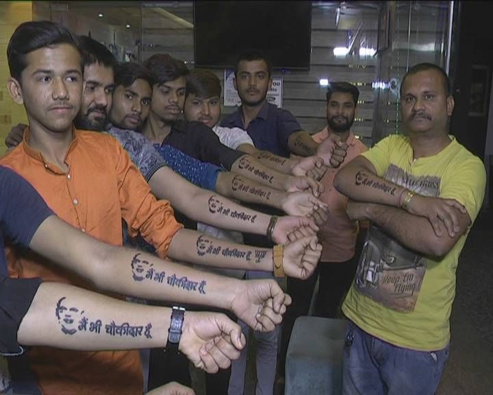 હિંમતનગરમાં લોકોના હાથ પર મફતમાં એક વ્યકિત લખી રહ્યો છે 'મેં ભી ચોકીદાર હુ'