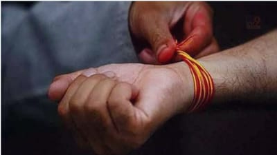 હિન્દુ ધર્મ મુજબ જ્યારે જ્યારે દેવી દેવતાની પૂજા કરવામાં આવે છે ત્યારે પૂજામાં બેસતા સૌથી પહેલા હાથમાં લાલ રંગની નાડાછળી કે દોરો બાંધવામાં આવે છે. ત્યારે ખાસ કરીને અત્યારે નવરાત્રીનો સમય છે ભક્તો માતાજીની પૂજા કરતા હોય છે ત્યારે પૂજામાં બેસતા બ્રાહ્મણ તેમના હાથે નાડાછડી બાંધે છે. આપણે બધાએ પણ જોયું હશે કે કળા અને સંસ્કૃતિ સાથે જોડાયેલા કેટલાક નેતાઓ કે યુવાનોના હાથ પર લાલ અથવા તો લાલ પીળો દોરો બાંધેલો હોય છે. ત્યારે શું તમને ખબર છે આ નાડાછડી કેમ બાંધવામાં આવે છે ? (ફોટો ક્રેડિટ- સોશિયલ મીડિયા)