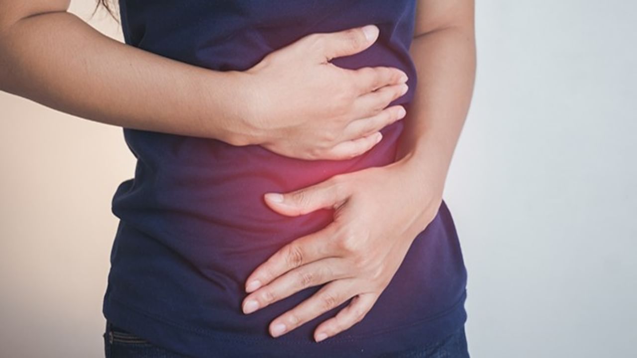 Midsection Of Woman Hands On Aching Stomach Against White Background