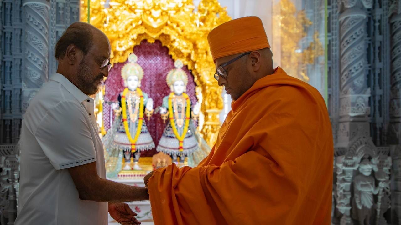In this photo, the saint can be seen tying a thread on Rajinikanth's wrist and gifting him a book before leaving the temple. In the pictures and videos, the actor is seen admiring the architecture of the temple.