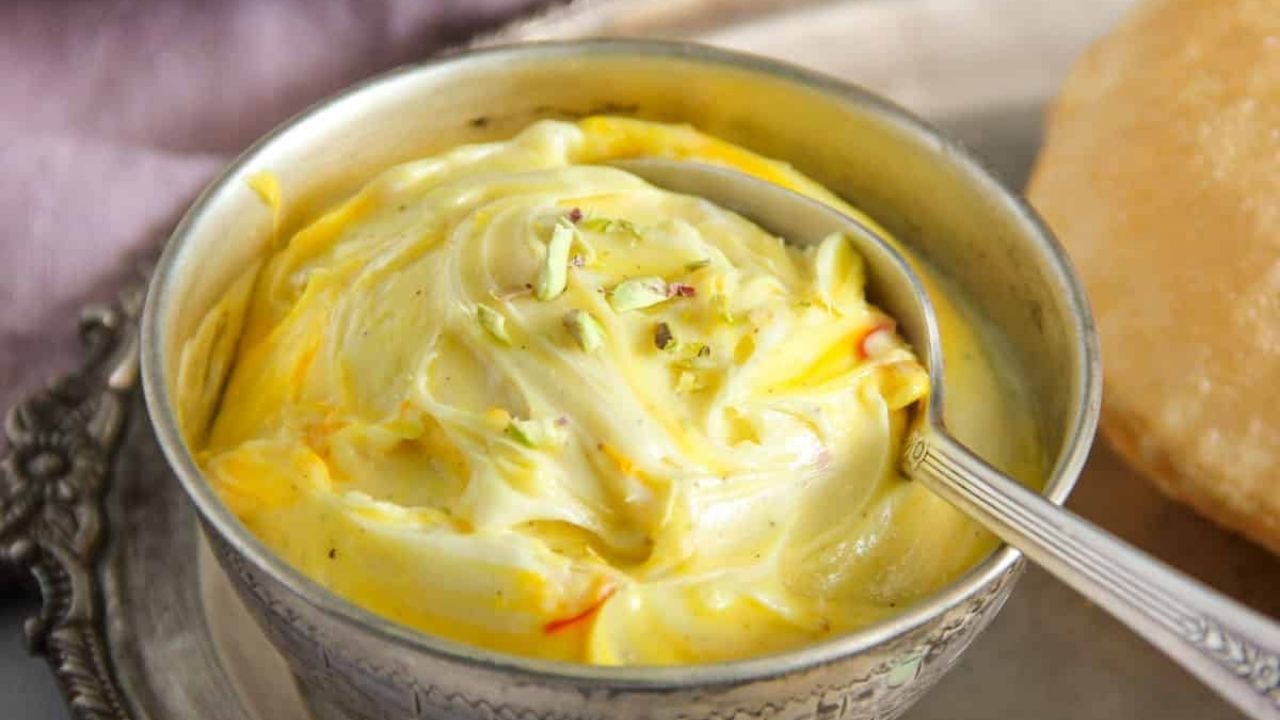  હવે પાણી નીકળી જાય પછી દહીંને એક વાસણમાં લો. તેમાં ખાંડ, કેશર અને ઈલાયચી પાઉડર ઉમેરો. આ સાથે જ બધી સામગ્રીને સારી રીતે મિક્સ કરો. 