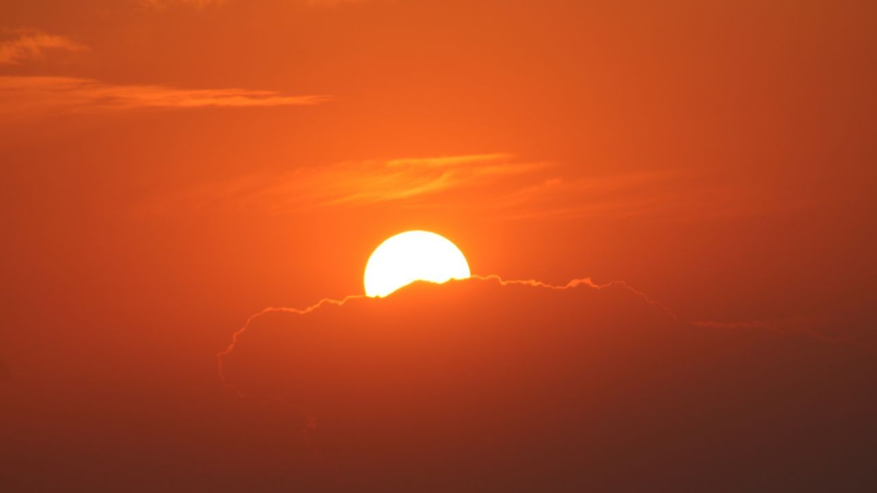 સવારે (સૂર્યોદય) અને સાંજે (સૂર્યાસ્ત) સમયે, સૂર્યના કિરણોને પૃથ્વીના વાયુમંડળમાંથી ઘણી લાંબી યાત્રા કરવી પડે છે.આ લાંબી યાત્રા દરમ્યાન, વારંવાર સ્કેટરિંગ થાય છે. નાની તરંગલંબાઈ ધરાવતાં રંગો ખાસ કરીને વાદળી અને નિલા પહેલેથી જ સ્કેટર થઈ જાય છે અને આપણાં સુધી પહોંચતા નથી.પરિણામે, લાલ અને નારંગી રંગો, જેમની તરંગલંબાઈ મોટી છે અને જે ઓછું વિખેરાય છે, એ આપણા સુધી પહોંચે છે. એટલે જ સવારે અને સાંજે સૂર્ય અને આસપાસનું આકાશ લાલ કે નારંગી રંગનું દેખાય છે. (Credits: - Canva)