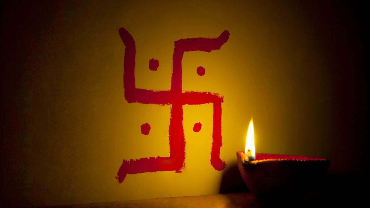 સ્વસ્તિક માતા લક્ષ્મી અને વિઘ્નહર્તા ગણેશજીનું પ્રિય ચિહ્ન છે. ઘરમાં ધર્મભાવના અને પવિત્રતાનું વાતાવરણ રહે છે. દરવાજા પર દક્ષિણાવર્ત સ્વસ્તિક ઘરમાં પ્રવેશતી ઊર્જાને પવિત્ર અને લાભદાયી બનાવે છે. ઘરના મુખ્ય કેન્દ્રો પર બનાવેલો સ્વસ્તિક પોઝિટિવ વાઇબ્રેશન ફેલાવે છે. ( Credits: Getty Images )