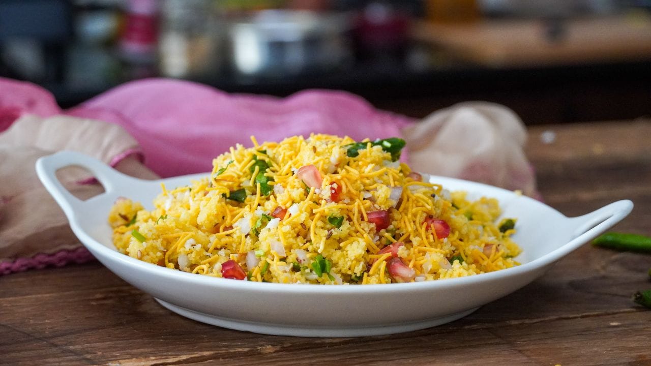 સેવ ખમણી બનાવવા માટે હવે ખમણને ખમણી નાખો. ત્યારબાદ એક કડાઈમાં તેલ ગરમ કરવા મુકો ત્યારબાદ તેમાં રાઈ, લીલા મરચા, મીઠો લીમડો, આદુ-મરચાંની પેસ્ટ ઉમેરો. હવે સેવ ખમણીનું ખમણ ઉમેરી બરાબર મિક્સ કરો. 