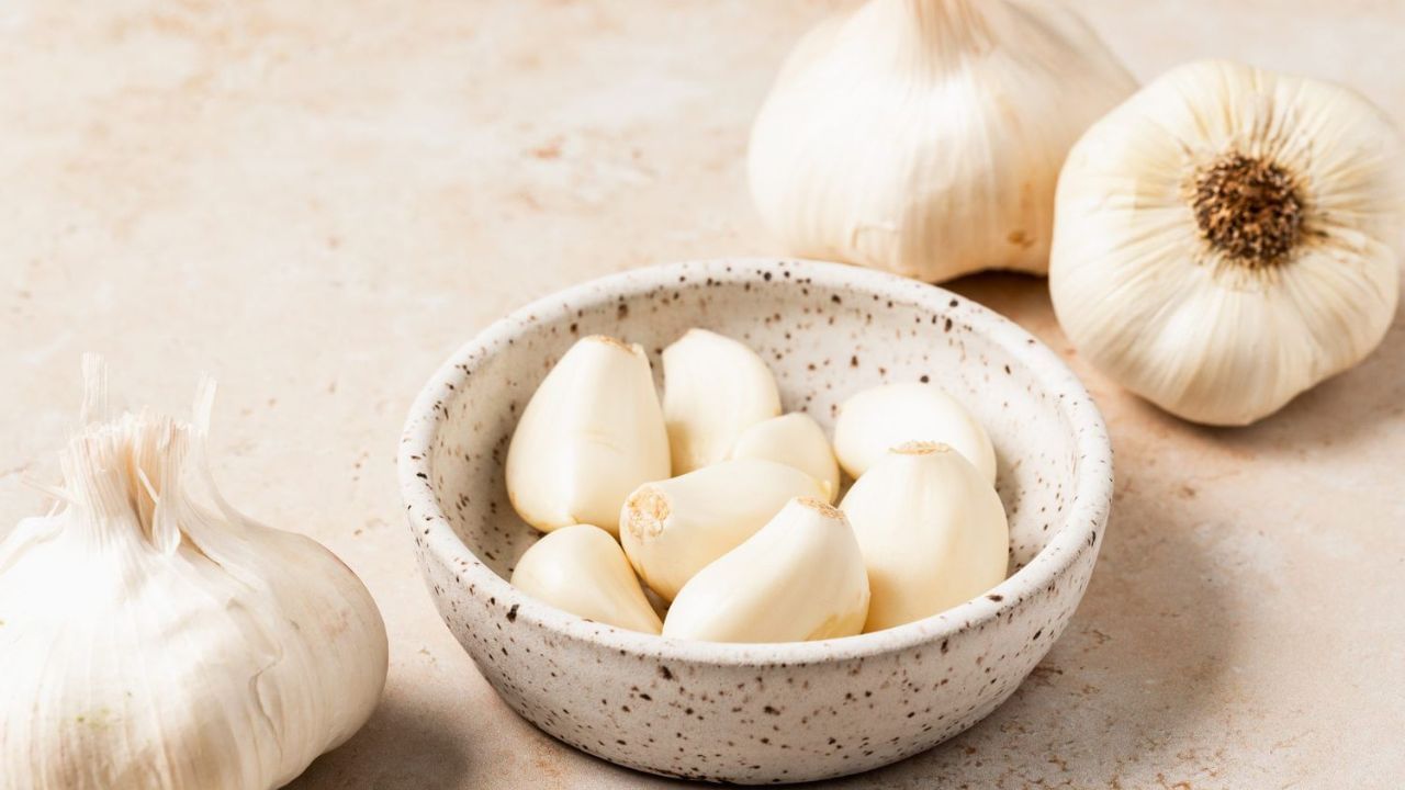 લસણ (Garlic): લસણને હૃદયના સ્વાસ્થ્ય માટે શ્રેષ્ઠ કુદરતી દવા માનવામાં આવે છે. તેમાં એલિસિન નામનું એક્ટિવ સંયોજન હોય છે જે કોલેસ્ટ્રોલ ઘટાડવામાં, બ્લડ પ્રેશરને નિયંત્રિત કરવામાં અને ધમનીઓમાં જમા થયેલી ચરબી સાફ કરવામાં મદદ કરે છે. સંશોધનમાં જાણવા મળ્યું છે કે નિયમિતપણે કાચું લસણ ખાવાથી હૃદયરોગનો હુમલો અને અવરોધનું જોખમ ઓછું થાય છે. દરરોજ સવારે ખાલી પેટે કાચા લસણની એક કે બે કળી ચાવીને ખાઓ.
