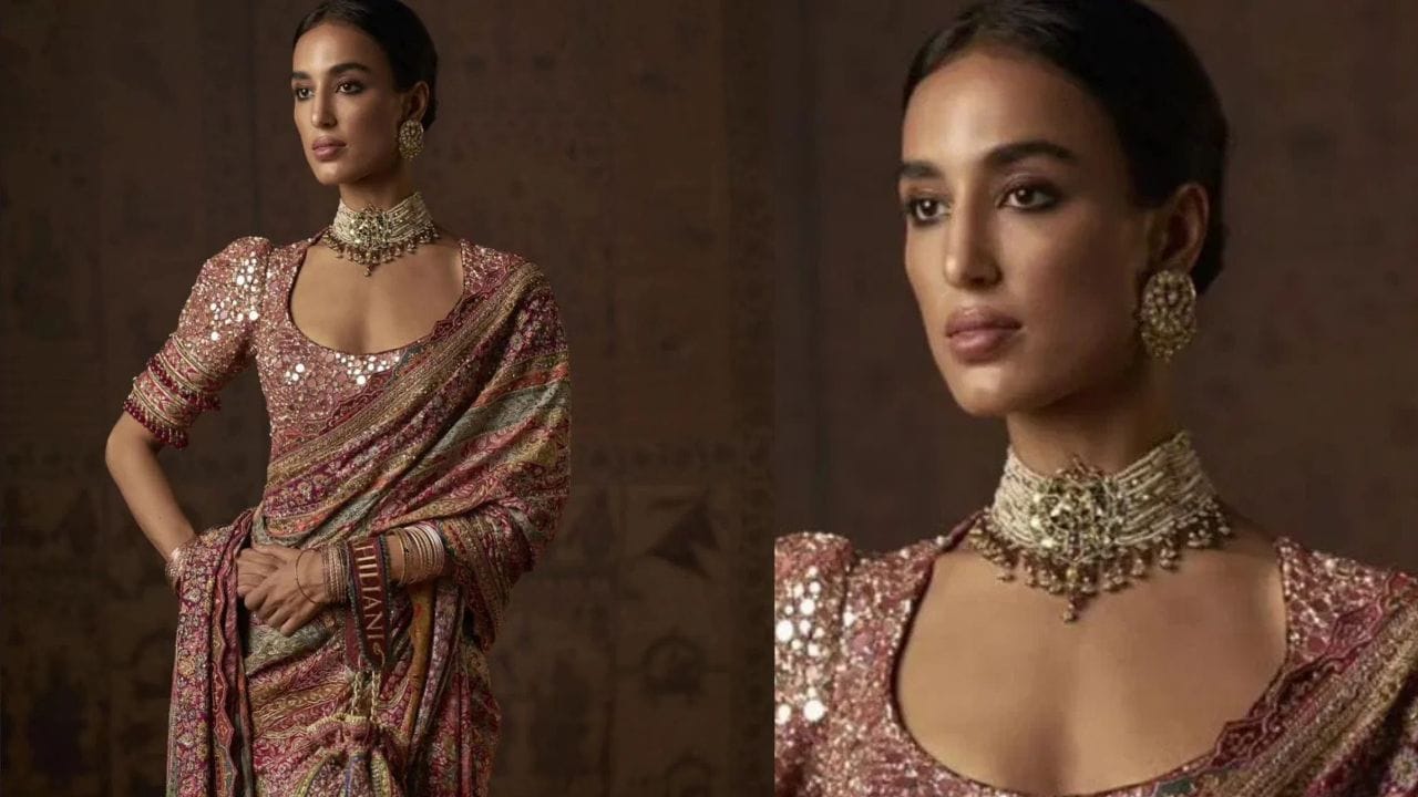 હાર્દિક પંડ્યાની રુમર્ડ ગર્લફ્રેન્ડ માહિકા શર્મા, આ ફોટામાં ભારે સિક્વન્સવાળી સાડી પહેરેલી જોવા મળે છે. તેણીએ મેચિંગ બ્લાઉઝ સાથે જોડી બનાવી છે. તેણીએ ચોકર સેટ અને મેચિંગ સ્ટડ્સ સાથે સાડી પહેરી છે. સ્લીક બન અને ન્યૂડ મેકઅપ સાથે માહિકા ખૂબ જ સુંદર લાગે છે.