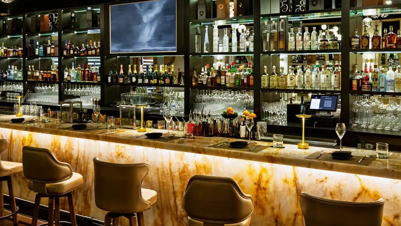 બારનું વાતાવરણ કેવું હોય છે?: બાર મુખ્યત્વે દારૂ અને પીણાં પીરસે છે. તેમાં સામાન્ય રીતે એક કાઉન્ટર અને બેસવાની જગ્યા હોય છે જ્યાં લોકો આરામથી બેસી શકે છે અને તેમની પસંદગીના દારૂ અથવા પીણાંનો આનંદ માણી શકે છે. બારનું વાતાવરણ સામાન્ય રીતે શાંત હોય છે, જેમાં થોડો ડાન્સ અથવા લાઈવ મ્યુઝિક હોય છે. આ સ્થળ એવા લોકો માટે છે જેઓ રેસ્ટ કરવા અને પીણાંનો આનંદ માણવા અને મિત્રો અથવા સાથીદારો સાથે સમય વિતાવવા માંગે છે.