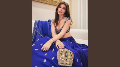 રોયલ બ્લુ શણગારેલા લહેંગામાં એલનાઝ ભવ્ય અને અદભુત લાગી રહી છે. ગોલ્ડન એમ્બ્રોઇડરી સાથેનું ગ્રીડ ડિટેલિંગ અને ભારે ડિઝાઇનવાળું બ્લાઉઝ તેમની સુંદરતાને વધારે છે. સ્ટેટમેન્ટ ચોકર અને ઇયરિંગ્સ સાથેનો મિનિમલ મેકઅપ લુકને ક્લાસી ટચ આપે છે. લગ્ન સમારંભ માટે આ લુક પરફેક્ટ પસંદગી બની શકે.