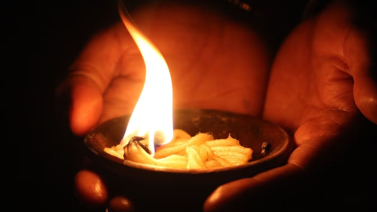 દીવામાં વપરાતી નાની વાટ પણ વ્યક્તિના જીવન પર ઊંડી અસર કરી શકે છે. જો તમે આર્થિક મુશ્કેલીઓમાંથી મુક્તિ મેળવવા માંગતા હો, તો વાટ બનાવતા પહેલા તેના પર થોડી માત્રામાં ચંદન લગાવવાનો પ્રયાસ કરો, અને પછી ઘીનો ઉપયોગ કરીને દીવો પ્રગટાવો. આનાથી ઘરમાં સુગંધ અને સકારાત્મક ઉર્જાનો સંચાર થાય છે. (ફોટો ક્રેડિટ-AI Whisk)