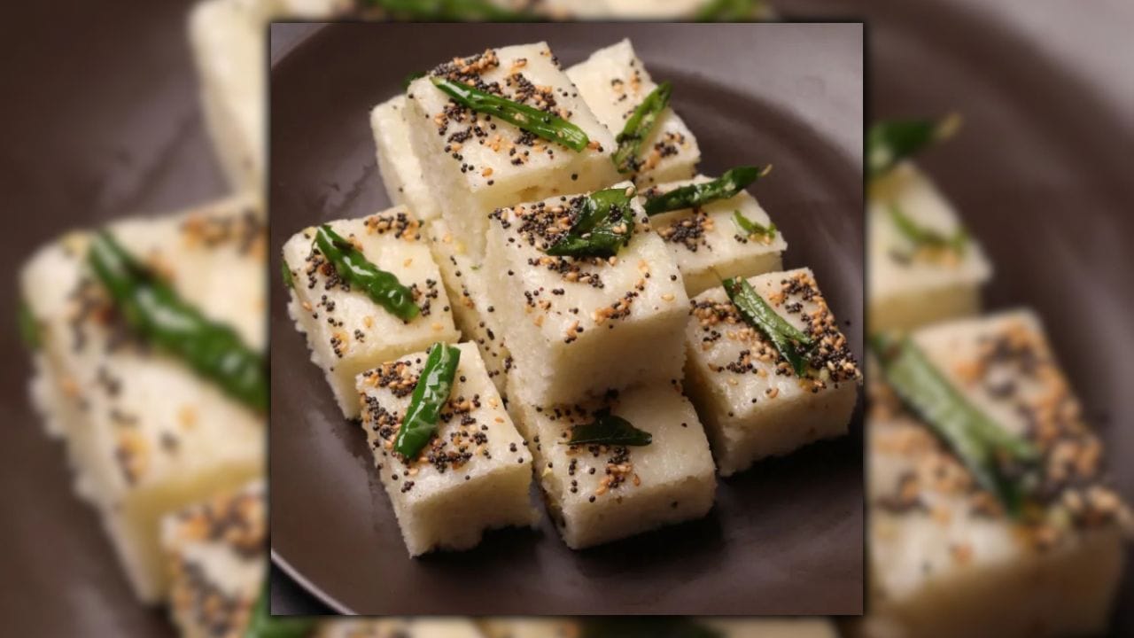 ગુજરાતી રસોઈની ઓળખ બની ગયેલા ઢોકળાં આજે માત્ર એક નાસ્તો નથી, પરંતુ તે પ્રાચીન ભારતીય રસોઈ પરંપરાનું જીવંત ઉદાહરણ છે. તેની પાછળનો ઇતિહાસ લગભગ 1000 વર્ષ જૂનો છે, જે આપણને 11મી સદી સુધી લઈ જાય છે. (Image Credit Source: Social Media)