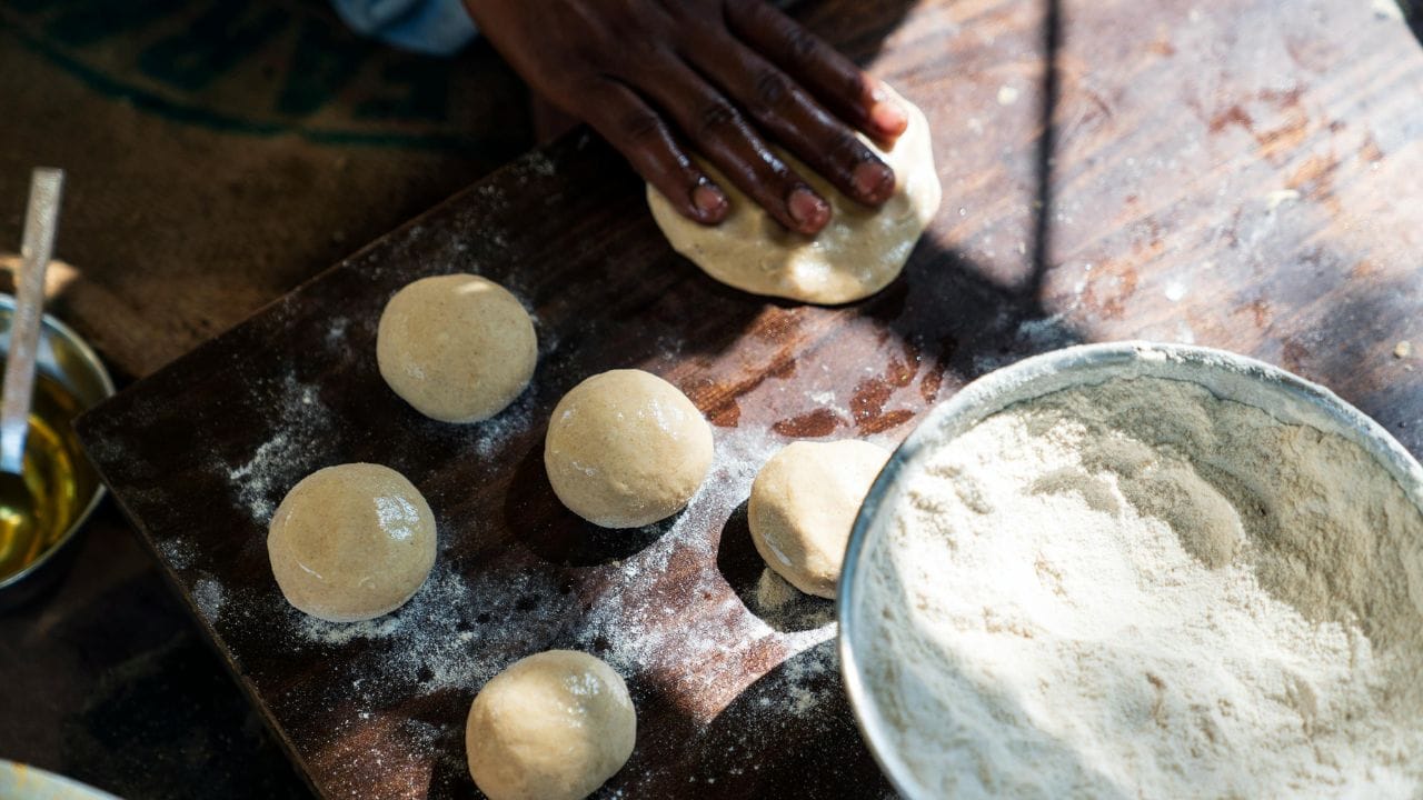 લોટ બાંધતા વખતે ઠંડા પાણીની જગ્યાએ હળવું નવશેકું પાણી વાપરવું જોઈએ. આથી લોટ વધુ નરમ અને લચીલો બને છે અને રોટલી સારી રીતે ફૂલે છે. (Image Credit Source: Social Media)